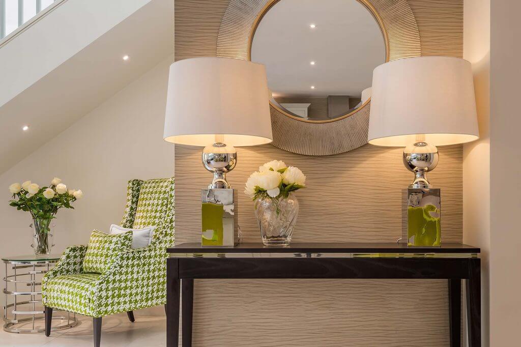 Sophisticated console table and green armchair seating nook interior
